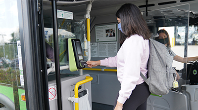 Femme présentant sa carte à un nouvel appareil PRESTO dans un autobus