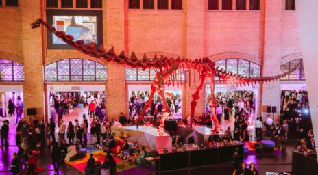 Exposants au ROM de nuit autour d’un squelette de dinosaure