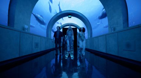 Groupe d’amis marchant à travers une exposition sous-marine à Arcadia Earth.