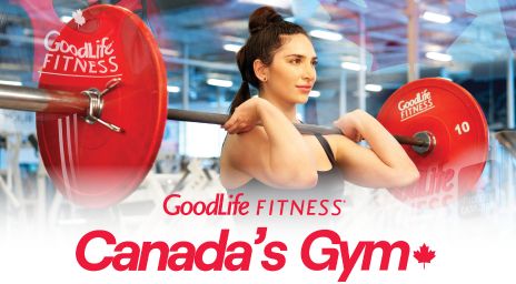 Une personne soulevant une barre avec des poids rouges dans un gymnase, avec le texte « GoodLife FITNESS Gym du Canada » affiché.
