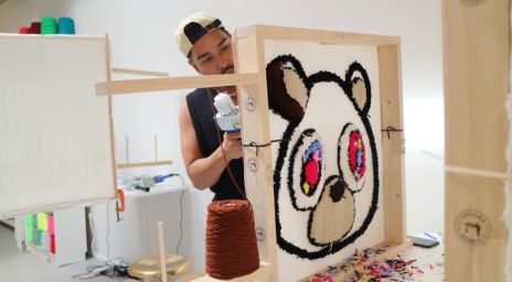 Mâle tuftant un tapis conçu comme un ours