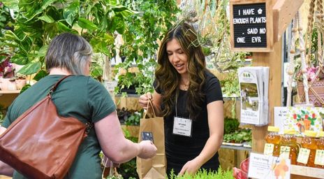 Fournisseur au Salon national de l’habitation remettant un panier-cadeau à un client lors d’une transaction