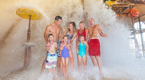 Une famille se fait éclabousser par un grand seau au parc aquatique du Great Wolf Lodge