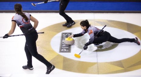 Des femmes qui font du curling sur la glace